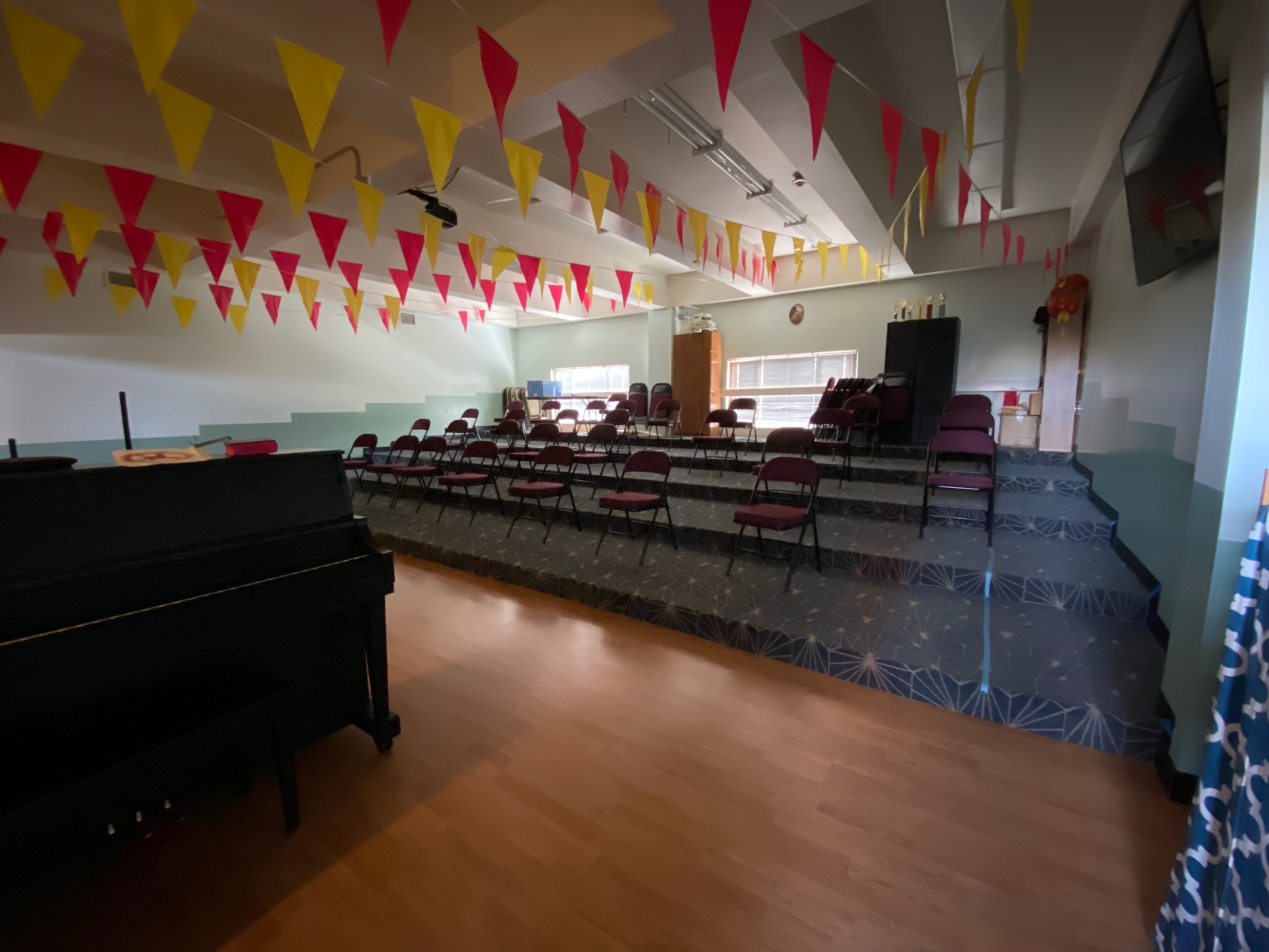 Room 210 has a whiteboard, projector/screen, large TV, and a piano.