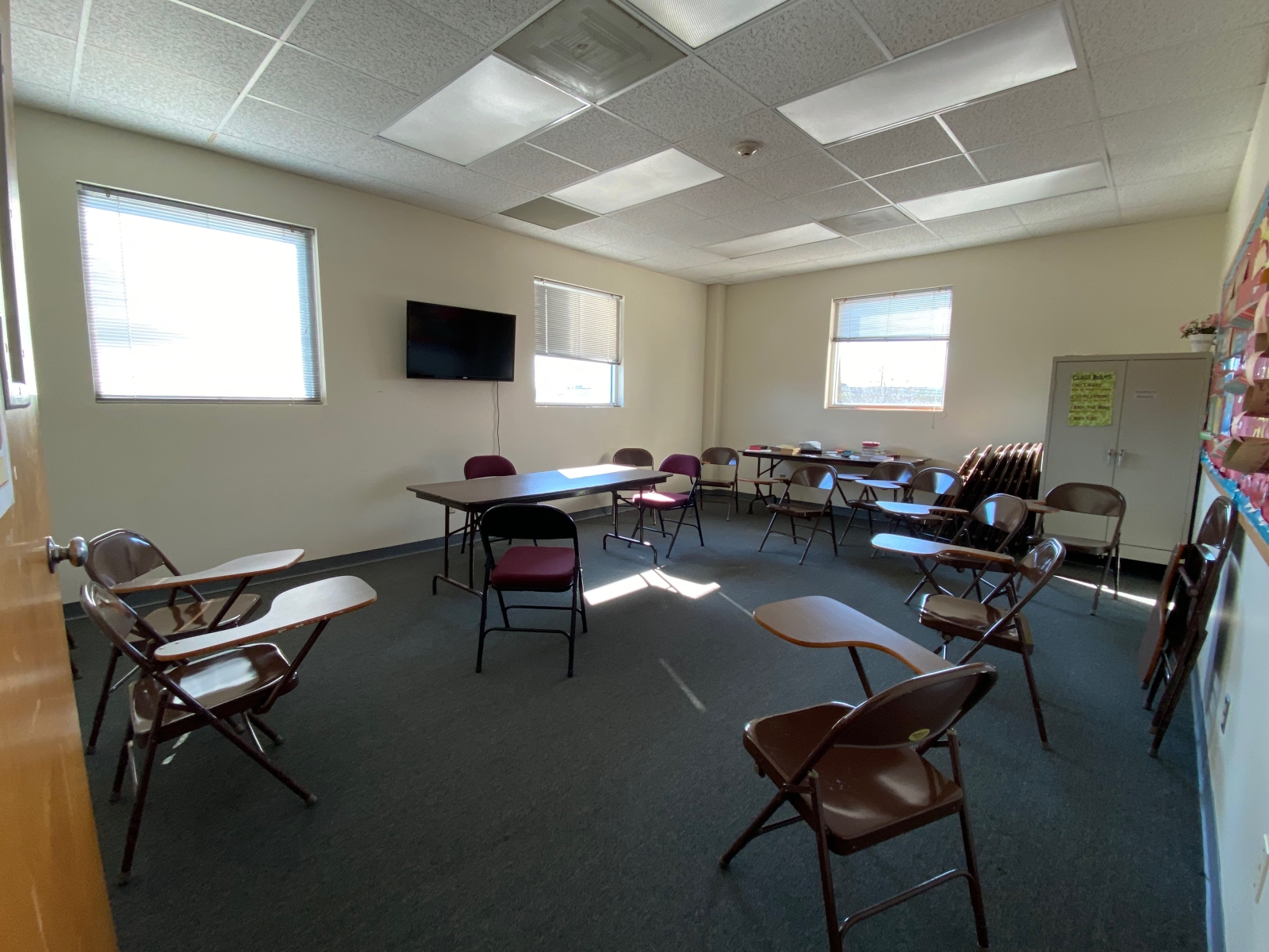Room 220 has a table, a TV, and student desks.